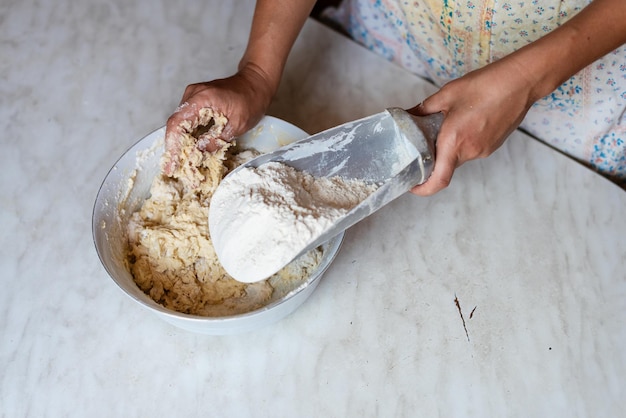 Manos de una mujer joven amasando masa para hacer pan o pizza en casa Producción de productos de harina Elaboración de masa por manos femeninas