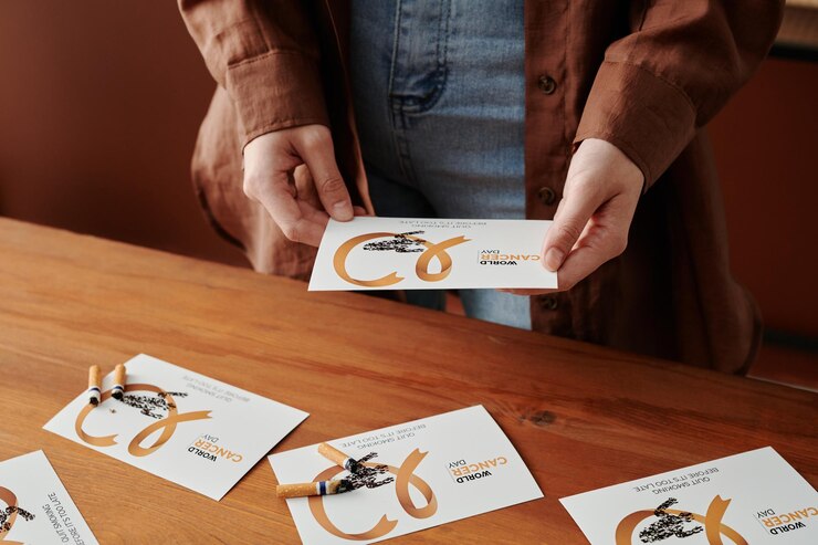Foto las manos de una mujer joven irreconocible sosteniendo una tarjeta con una cinta de cáncer de pulmón