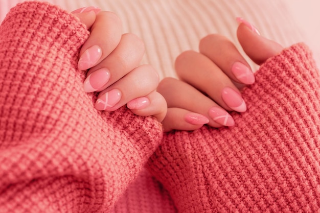 Manos de mujer con manicura con manta tejida