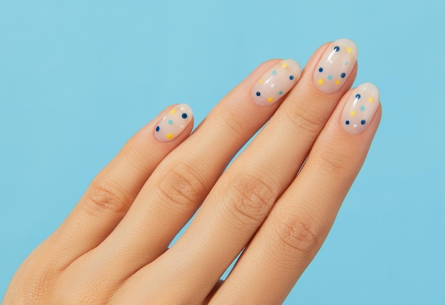 Foto manos de mujer con manicura de verano de lunares de moda