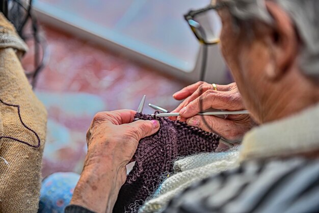 Manos de una mujer mayor que trabaja en la artesanía