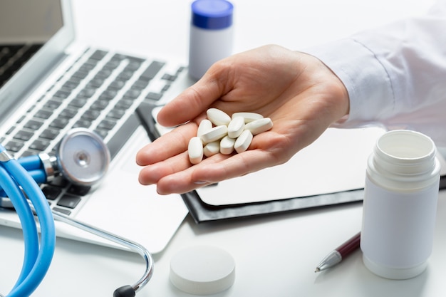 Manos de la mujer del médico con la computadora portátil.