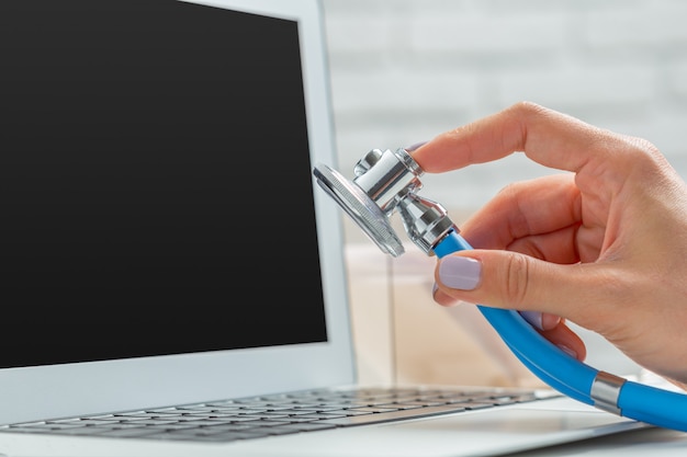 Manos de mujer médico con laptop.