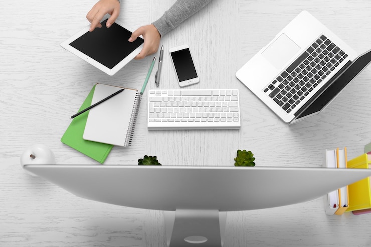Foto las manos de la mujer en la mesa con computadora, tableta, teléfono inteligente y otras cosas vista superior