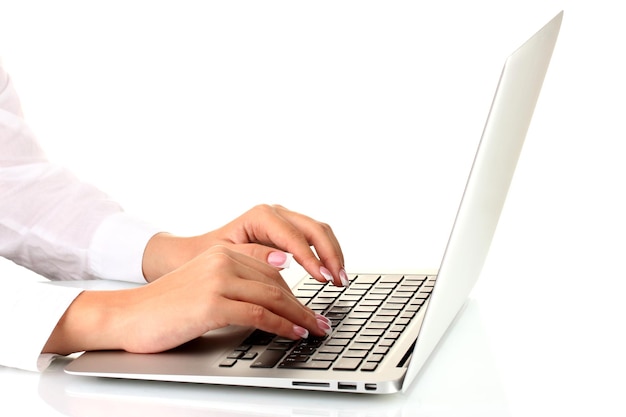 Las manos de una mujer de negocios escribiendo en una computadora portátil en un primer plano de fondo blanco