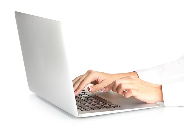 Las manos de una mujer de negocios escribiendo en una computadora portátil en un primer plano de fondo blanco