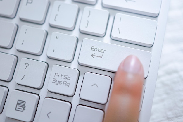 Manos de mujer de negocios presionando el botón enter en el teclado de la computadora