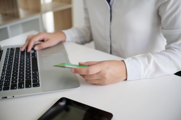 Manos de mujer de negocios sosteniendo una tarjeta de crédito de plástico y usando un teléfono inteligente portátil Concepto de compras en línea
