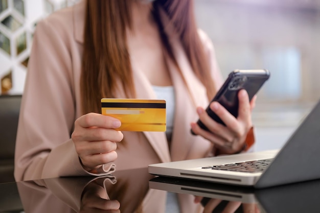 Manos de mujer de negocios usando teléfono inteligente y con tarjeta de crédito como compras en línea xA