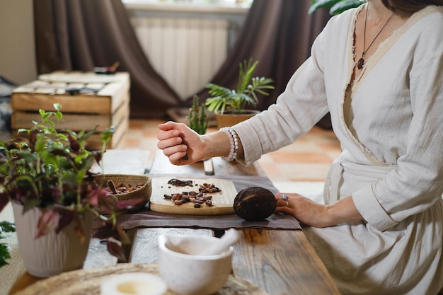 Manos de mujer pelando granos de cacao orgánico crudo para ceremonia