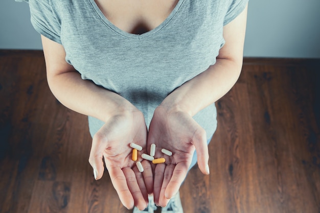 Manos de mujer de primer plano sosteniendo pastillas