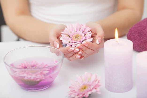 Manos de mujer recibiendo un exfoliante de mano pelado por una esteticista en salón de belleza. SPA manicura, masaje de manos y cuidado corporal. De cerca, dof superficial.