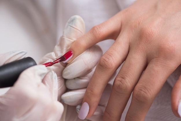 Manos de mujer recibiendo una manicura en un salón de belleza. Limado de uñas. Primer plano, enfoque selectivo.