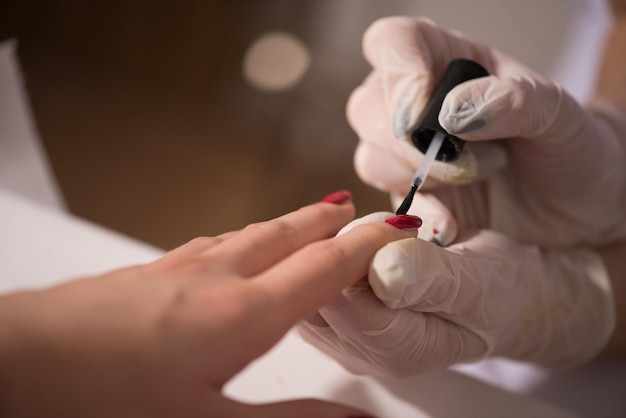 Manos de mujer recibiendo una manicura en un salón de belleza. Limado de uñas. Primer plano, enfoque selectivo.