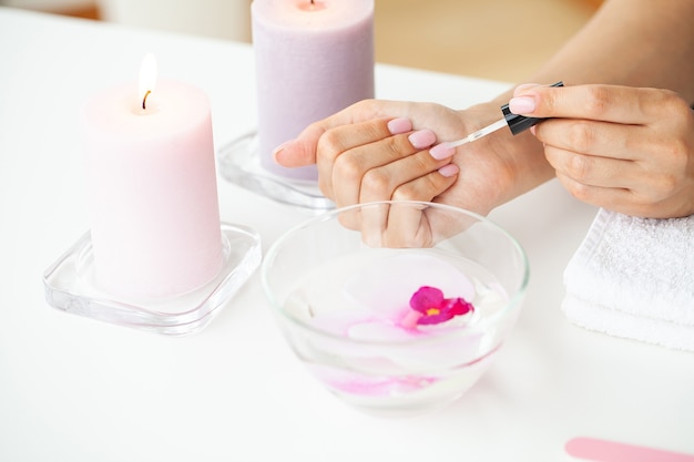 Manos de mujer recibiendo una manicura en salón de belleza.