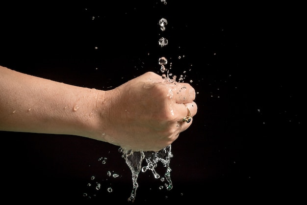 Manos de mujer con salpicaduras de agua