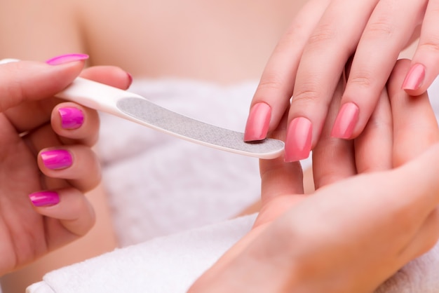 Manos de mujer durante la sesión de manicura