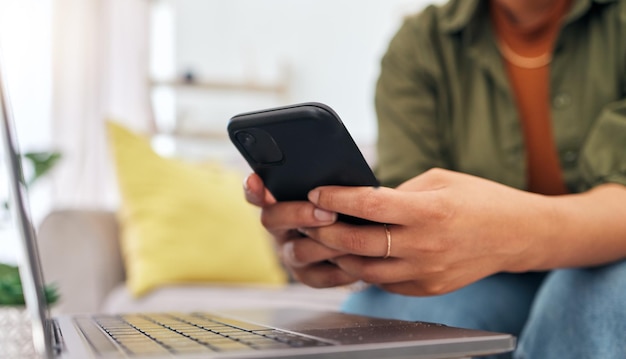 Manos de mujer en el sofá con teléfono portátil y escribiendo para investigación de trabajo remoto y documentos para trabajo en línea Redes de Internet y freelance de oficina en casa en sofá con teléfono celular y computadora