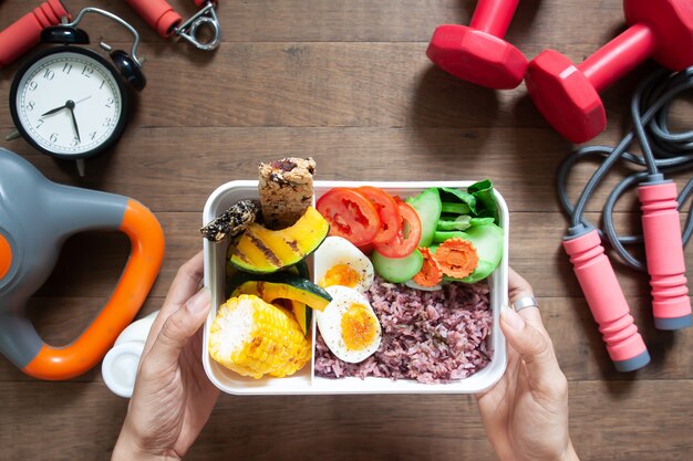 Manos de mujer sosteniendo la caja del almuerzo