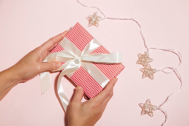 manos de mujer sosteniendo caja de regalo de navidad