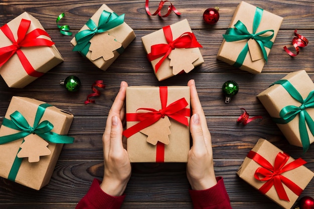 Manos de mujer sosteniendo caja de regalo preparando sorpresa para la vista superior de vacaciones Concepto de Navidad y Año Nuevo