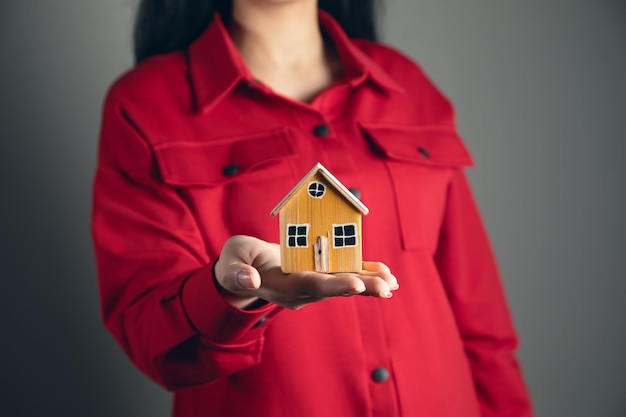 Manos de mujer sosteniendo casa modelo