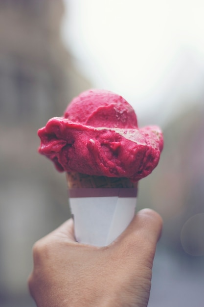 Foto manos de mujer sosteniendo cono de waffle de helado de fusión en manos de luz de verano