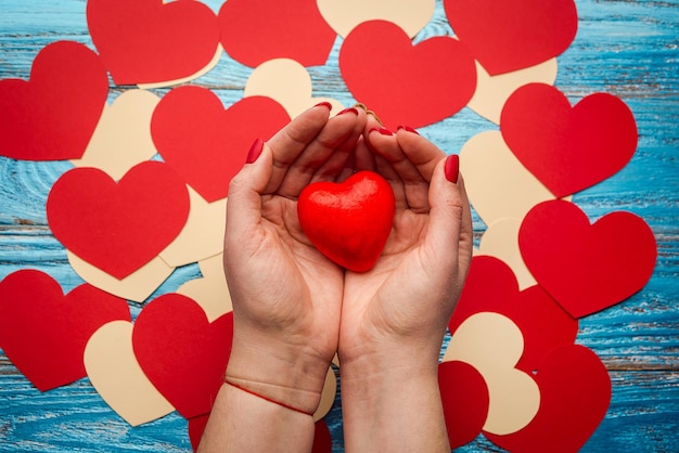 Manos de mujer sosteniendo corazón rojo fondo del día de San Valentín