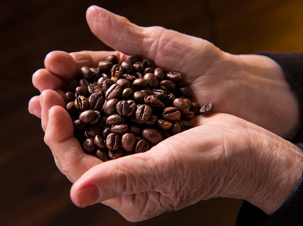 manos de mujer sosteniendo granos de café