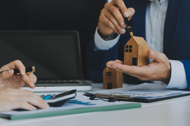 Manos de mujer sosteniendo el modelo de casa pequeña casa de juguete blanca en miniatura Seguro de propiedad hipotecaria sueño mudanza casa y concepto de bienes raíces