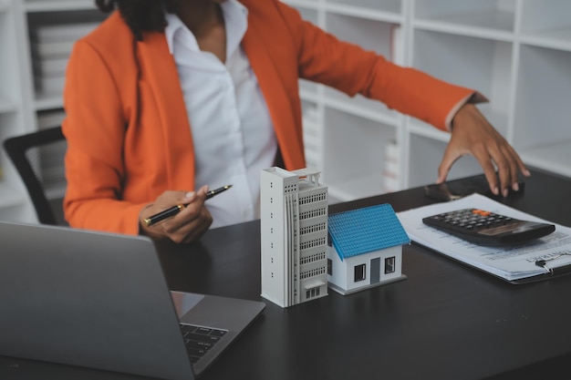 Las manos de la mujer sosteniendo el modelo de casa pequeña miniatura casa de juguetes blanca hipoteca seguro de propiedad sueño mudarse a casa y concepto de bienes raíces