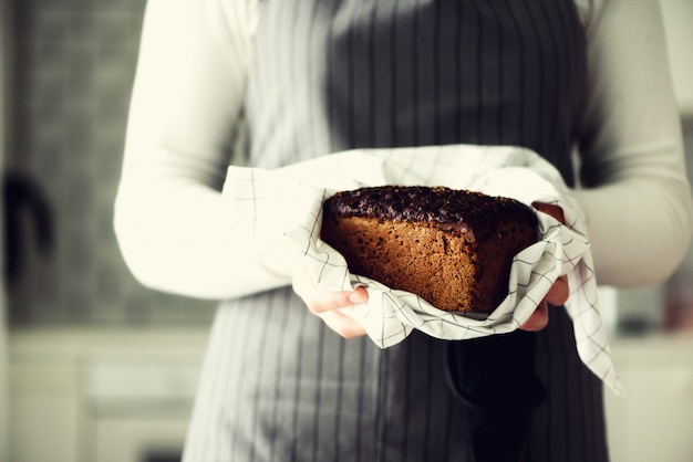 Manos de mujer sosteniendo pan recién horneado.