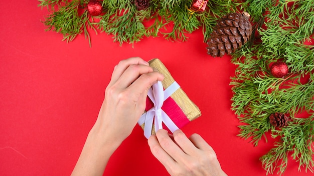 Manos de mujer sosteniendo un regalo rojo