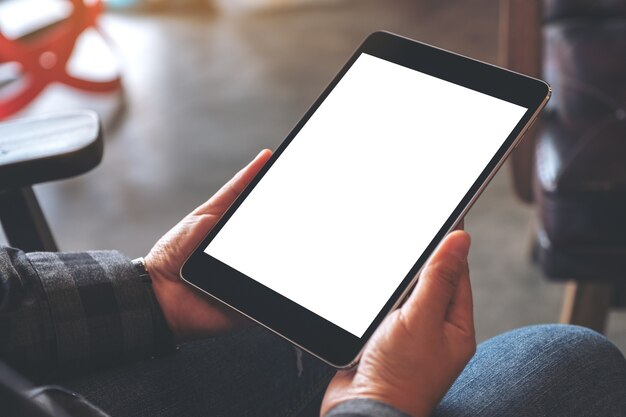 Manos de mujer sosteniendo tablet pc negro con pantalla en blanco en el café