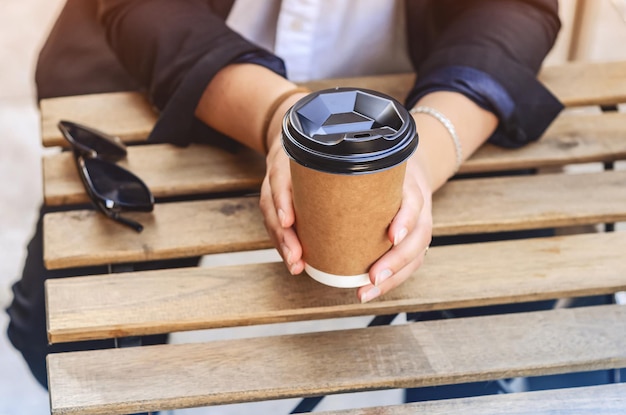 Foto las manos de la mujer sosteniendo una taza de cartón de café en un café callejero cubiertos ecológicos café caliente