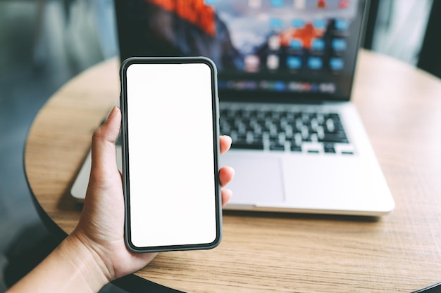 Manos de mujer sosteniendo teléfono celular en blanco copia espacio pantalla teléfono inteligente con pantalla en blanco en blanco aislado sobre fondo blanco teléfono inteligente con concepto de tecnología