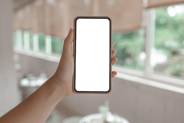 Manos de mujer sosteniendo teléfono celular en blanco copia espacio pantalla teléfono inteligente con pantalla en blanco en blanco teléfono inteligente aislado con concepto de tecnología