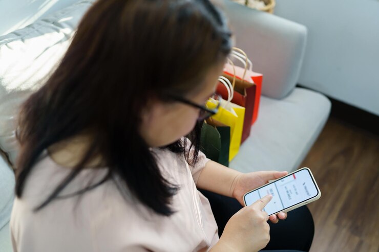 Foto manos de mujer sosteniendo teléfono celular usando smartphonexasale bolsas de compras consumismo concepto de estilo de vida en el centro comercial con bolsa de compras