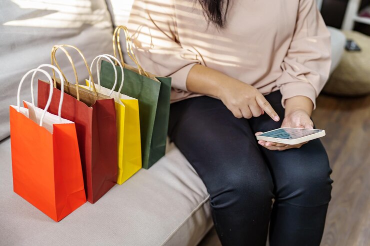 Foto manos de mujer sosteniendo teléfono celular usando smartphonexasale bolsas de compras consumismo concepto de estilo de vida en el centro comercial con bolsa de compras