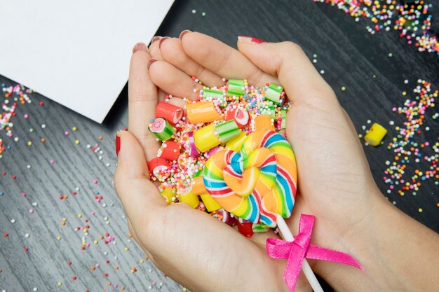 Foto las manos de la mujer sosteniendo una variedad de dulces coloridos