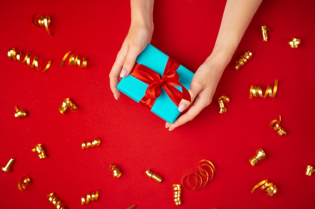 Foto manos de mujer sosteniendo la vista superior de la caja de regalo