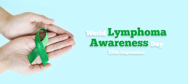 Las manos de la mujer sostienen una cinta verde que simboliza la lucha contra la enfermedad Conciencia mundial sobre el linfoma