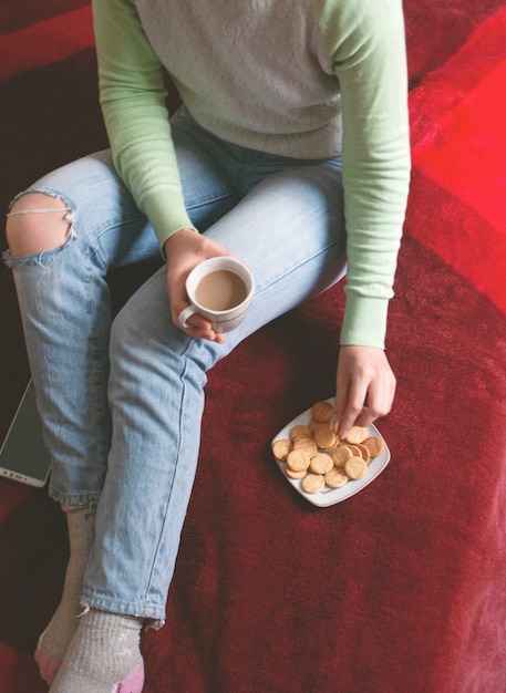 Las manos de la mujer sostienen una taza de café.