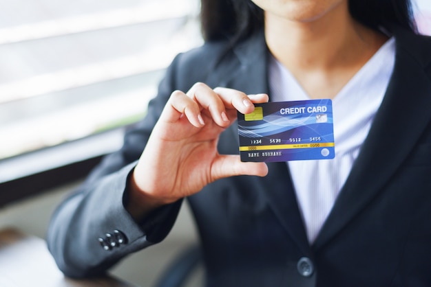 Foto manos de mujer con tarjeta de crédito para compras en línea en una oficina / gente de trabajo que paga tecnología en línea billetera dinero pago