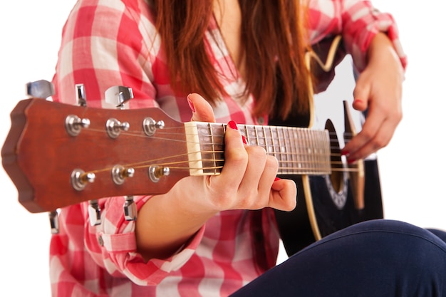 Manos de mujer tocando la guitarra acústica, de cerca. Aislado sobre fondo blanco