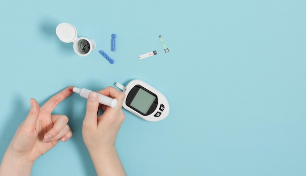 Manos de mujer usando glucómetro en el dedo para verificar el nivel de azúcar en la sangre Concepto de diabetes