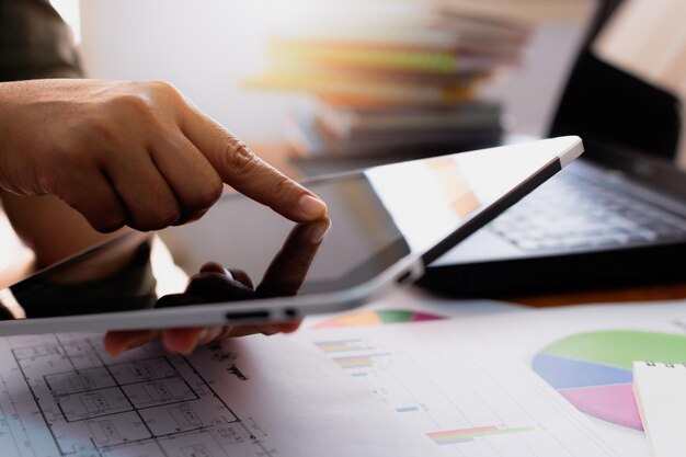 Manos de mujer usando tableta en el escritorio de trabajo en el concepto de negocios y tecnología de la oficina