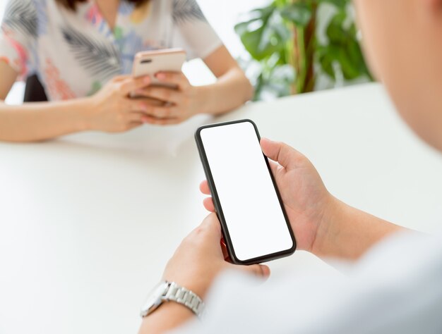 Manos de mujer usando un teléfono inteligente en el interior