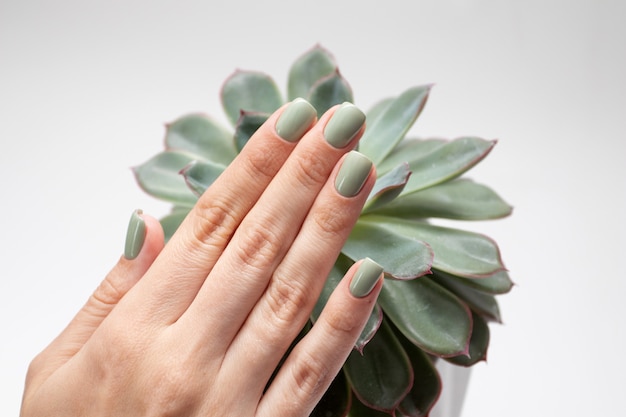 Foto manos de mujer con uñas de verano. manicura verde fresca.