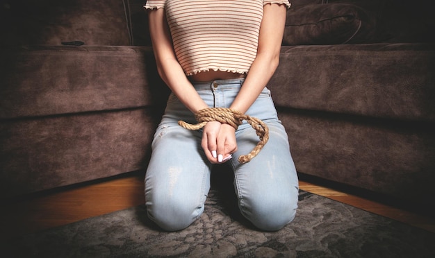 Manos de una mujer víctima atadas con una cuerda.